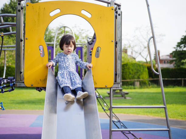 istock Girl Playing On Slide In Playground 1127783043
