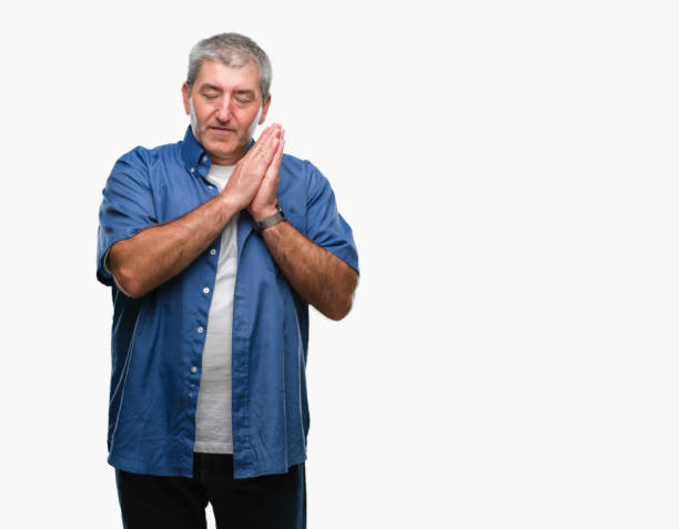 istock Handsome senior man over isolated background sleeping tired dreaming and posing with hands together while smiling with closed eyes. 1127786661