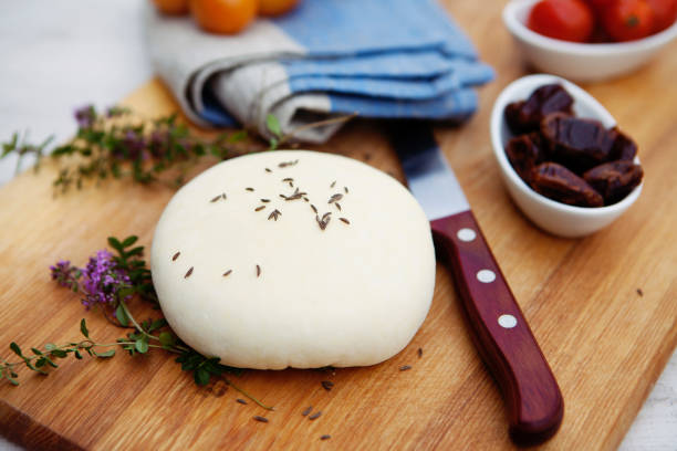 fresh homemade cottage cheese on a wooden cutting board with thyme, linen tea towel and kitchen knife. paleo diet. - farmers cheese imagens e fotografias de stock