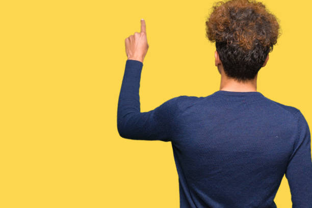 istock Young handsome man with afro hair Posing backwards pointing behind with finger hand 1127788008