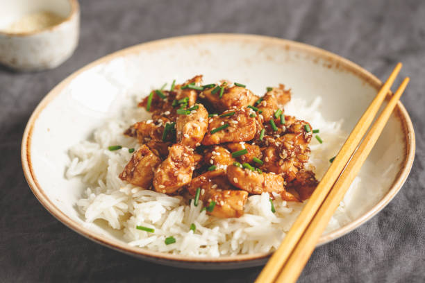 istock Sesame chicken pieces with rice on a ceramic plate. Chinese traditional dish. 1127788245