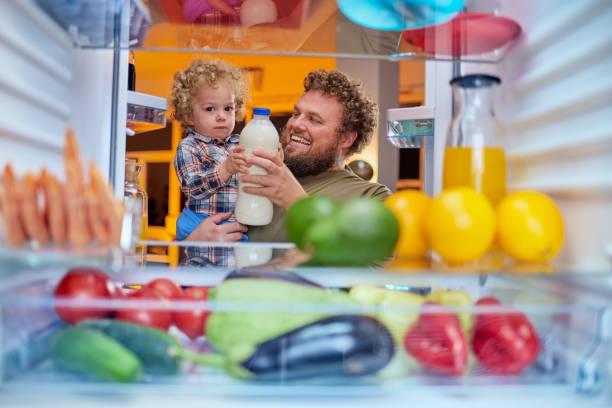 istock Father and son taking milk from fridge in late hours. 1127790270