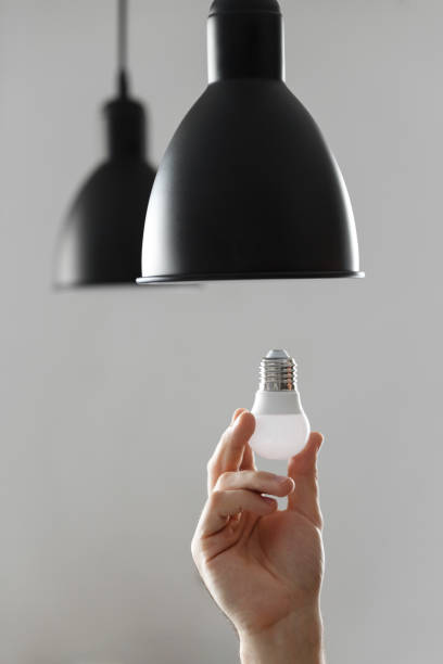 istock Changing the bulb for led bulb in floor lamp in black colour. On light gray background 1127793153
