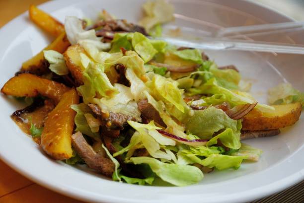istock a portion of fresh salad on a white plate with a fork 1127794707