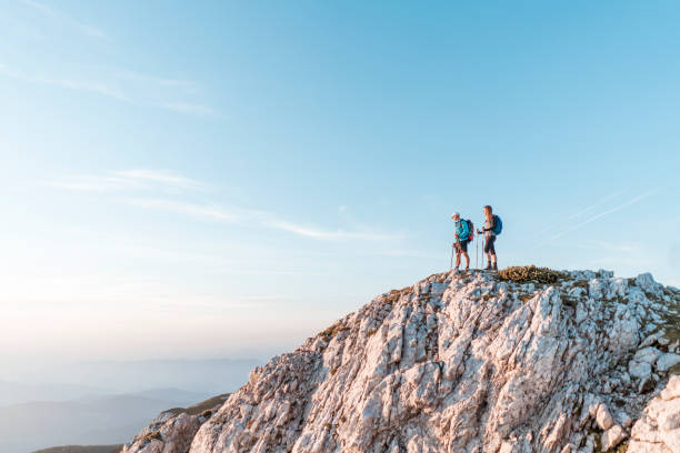 istock Hikers standing on the edge of a cliff 1127795346