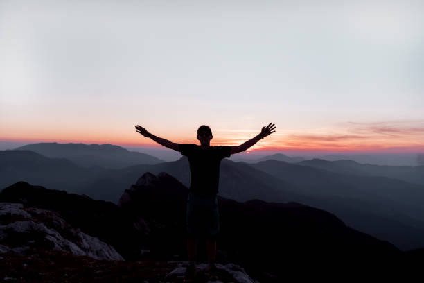 Sunset sky in the mountains. Dolomiti Alps range at sunset light, the sky burning blood red sunset with mountain peaks silhouettes and mysty clouds. Mountain rocky summit in red sunlight