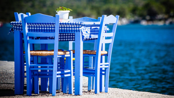 istock Open cafe outdoor restaurant in Greece on sea shore 1127797145