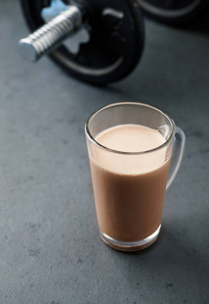 istock Chocolate Protein Shake and Dumbbells. Nutrition for bodybuilding. Black stone background. 1127798540