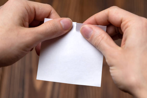 istock Closeup hands tearing empty sheet of paper. Mockup 1127798865