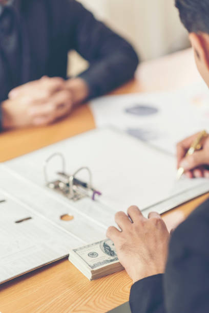 istock Close-Up Of Businessman Taking Bribe On Table At Office 1127799757