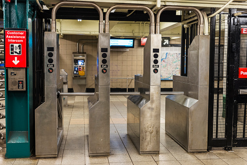 Automatic access control ticket barriers in subway station with signs of entry and exit in New York City, USA