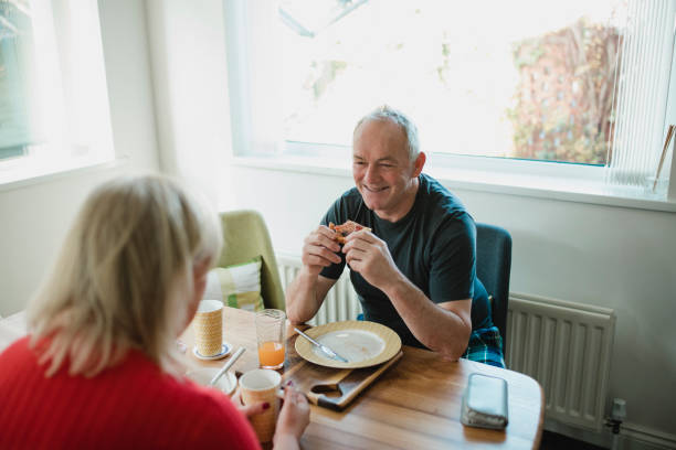 uomo anziano che si gode la colazione con sua moglie - non alcoholic beverage comfort food snack dining table foto e immagini stock