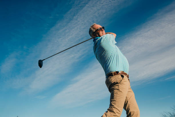 senior homme jouer golf - golf playing teeing off men photos et images de collection