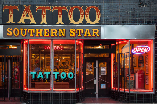 Atlanta, Georgia, USA – July 27, 2015: Night shot of the Southern Star Tattoo store window in Euclid Ave, Little Five Points.\nLittle Five Points is a district, on the east of Atlanta Downtown, famous for its bohemian atmosphere that brings alternative culture to the city