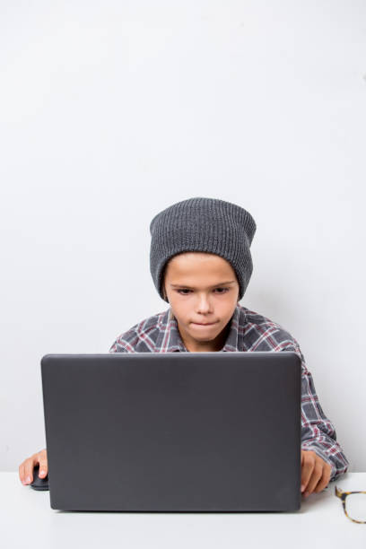 Handsome boy learning lessons, making research on laptop and browse internet
