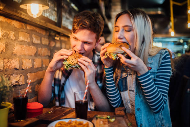istock Young couple eating hamburgers 1127809487