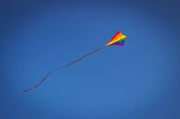 A colourful flighing kite against a beautiful blue sky. 