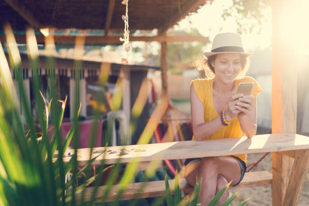 ビーチ休日のテキスト メッセージでツーリストの女性 - summer women hammock nature ストックフォトと画像