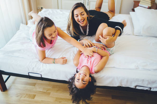 istock Mother with daughters playing together at home 1127816344