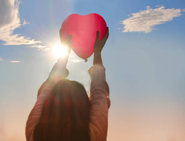 istock Girl holding heart shaped balloon 1127818694