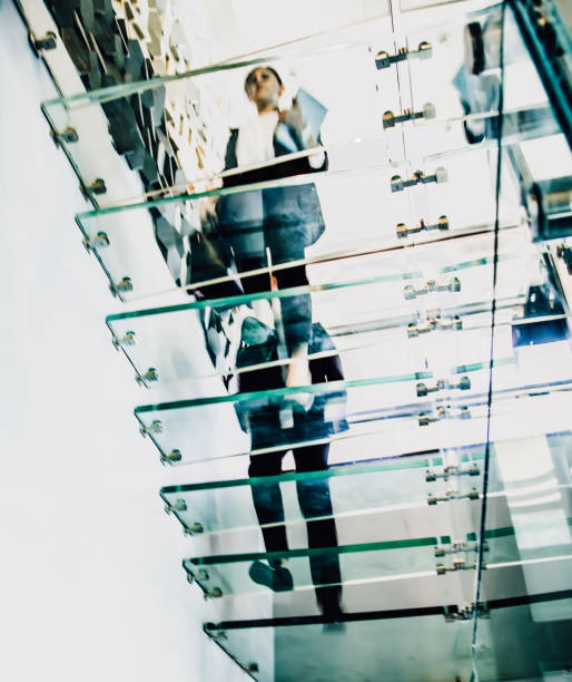 istock Business people walking on modern glass staircases 1127819005