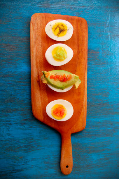 istock boiled egg garnish with avocado, tomato on blue wooden background 1127824137