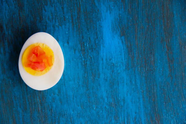 istock Boiled egg with bright yolk blue wooden background 1127824174