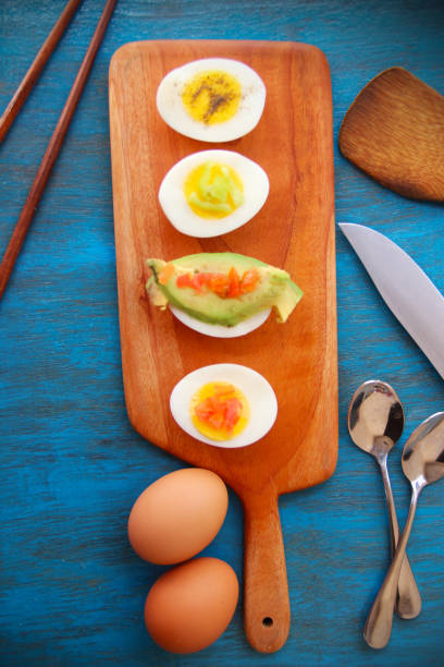 istock boiled egg garnish with avocado, tomato on blue wooden background 1127824227