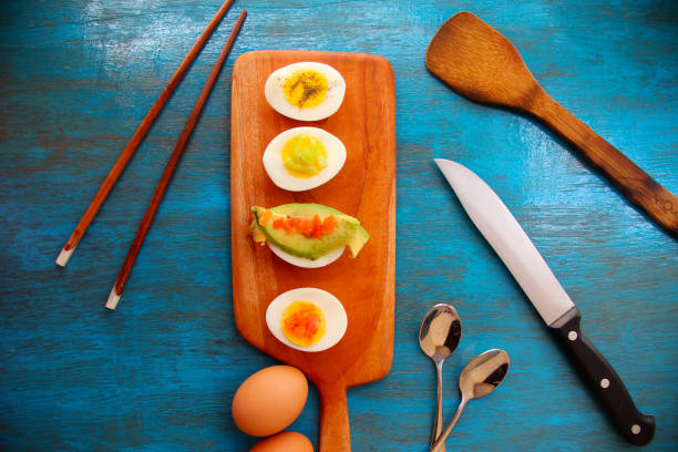 istock boiled egg garnish with avocado, tomato on blue wooden background 1127824250
