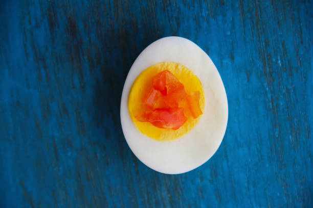 istock Boiled egg with bright yolk blue wooden background 1127824269
