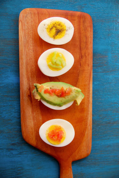 istock boiled egg garnish with avocado, tomato on blue wooden background 1127824284