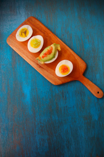 istock boiled egg garnish with avocado, tomato on blue wooden background 1127824375