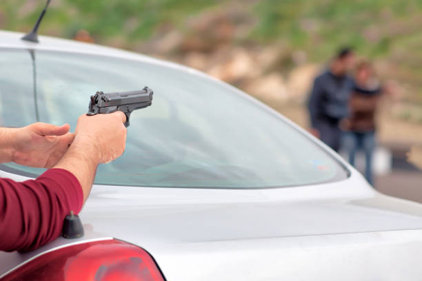 istock Car thief pointing a gun at the driver 1127824484