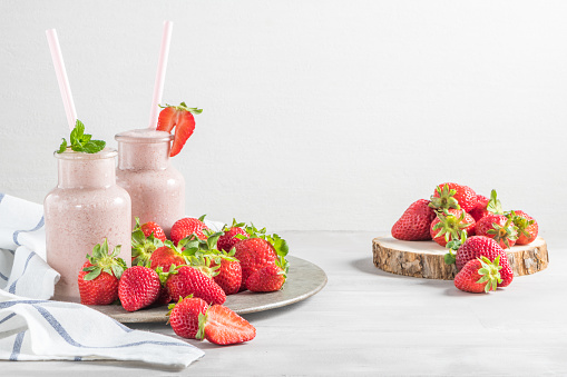 Strawberry milkshake or smoothie in glass jars on a table. Diet organic food. Top view with copy space