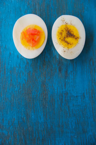 istock Boiled egg with bright yolk blue wooden background 1127824565