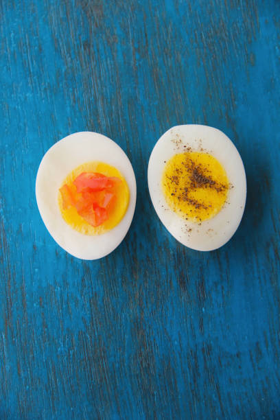 istock Boiled egg with bright yolk blue wooden background 1127824626