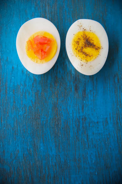 istock Boiled egg with bright yolk blue wooden background 1127824627