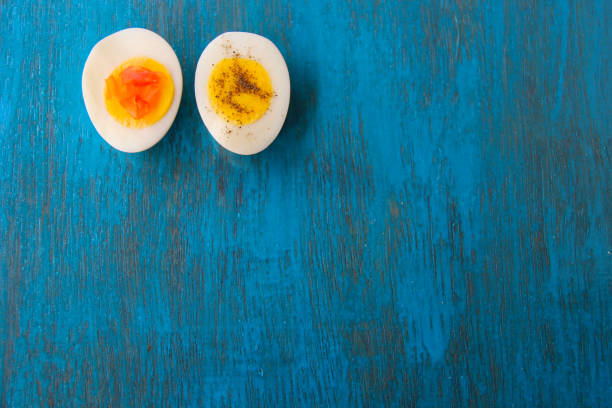 istock Boiled egg with bright yolk blue wooden background 1127825551