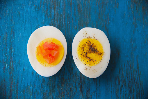 Boiled egg with bright yolk blue wooden background