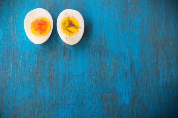 istock Boiled egg with bright yolk blue wooden background 1127825605