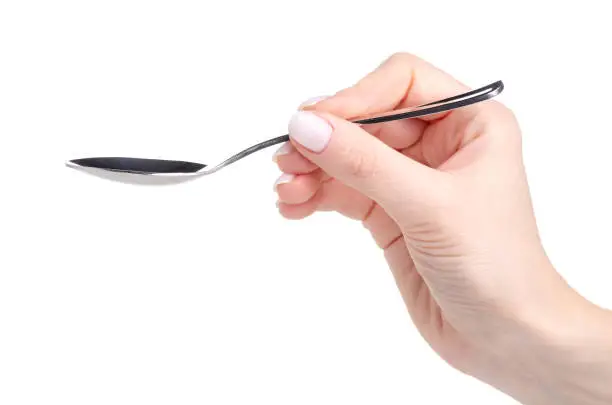 Tea spoon in hand on white background isolation