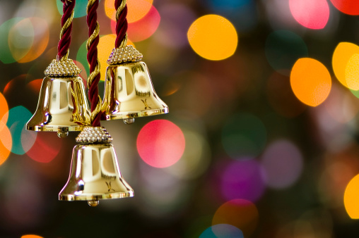 close up of bells ornament hangs on a christmas tree
