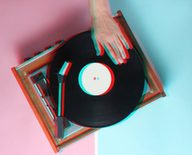 istock Female hands  use retro vinyl player on a blue pink pastel background. DJ. Top View 1127832059