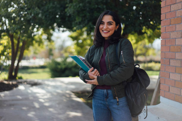 istock Female student with book in college campus 1127833020