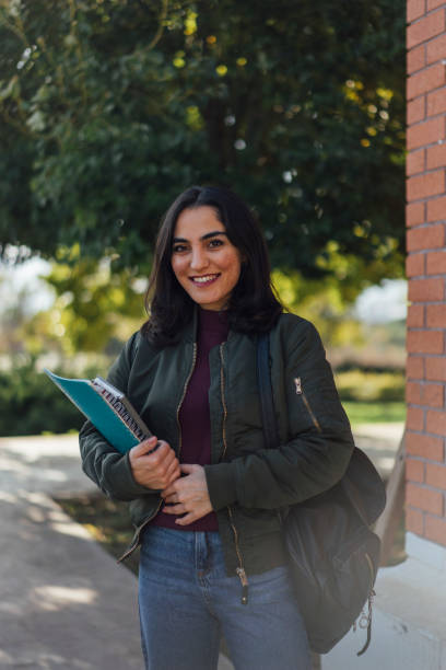 istock Female student with book in college campus 1127833111