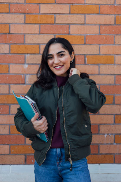 istock Female student with book in college campus 1127833115