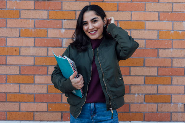 istock Female student with book in college campus 1127833176