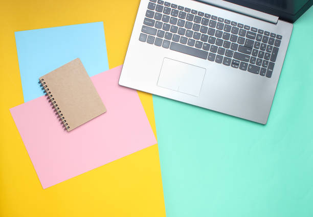 istock Laptop, notebook on a colored pastel background, modern workspace, minimalism, flat lay style, top view 1127833189