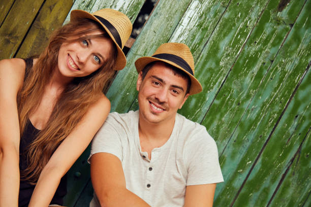 Young couple in summer outfit looking away, smiling, isolated on white background.