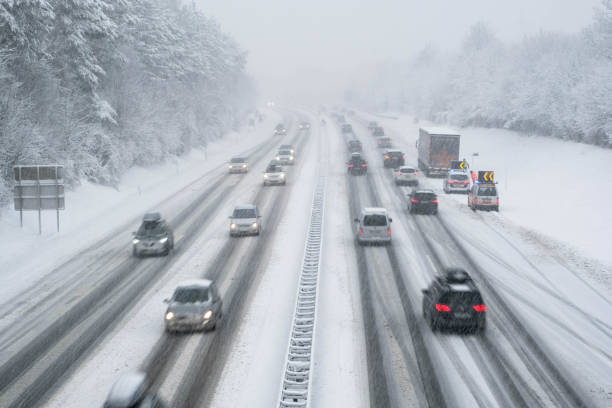 schneebedeckten autobahn in österreich mit autos außerhalb des fokus - driving conditions stock-fotos und bilder